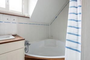 Une salle de bain avec une baignoire, un lavabo et une douche.
