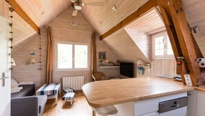 Un chalet confortable avec un intérieur en bois, un coin repas et une cuisine équipée d’un lave-vaisselle.