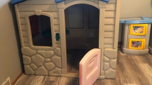 A children's playhouse with a stone facade, an open door, and a small window. - Hometown Cozy  ADA friendly, Kids, Pets, King Bed! Quiet, Safe Neighborhood (Medina)