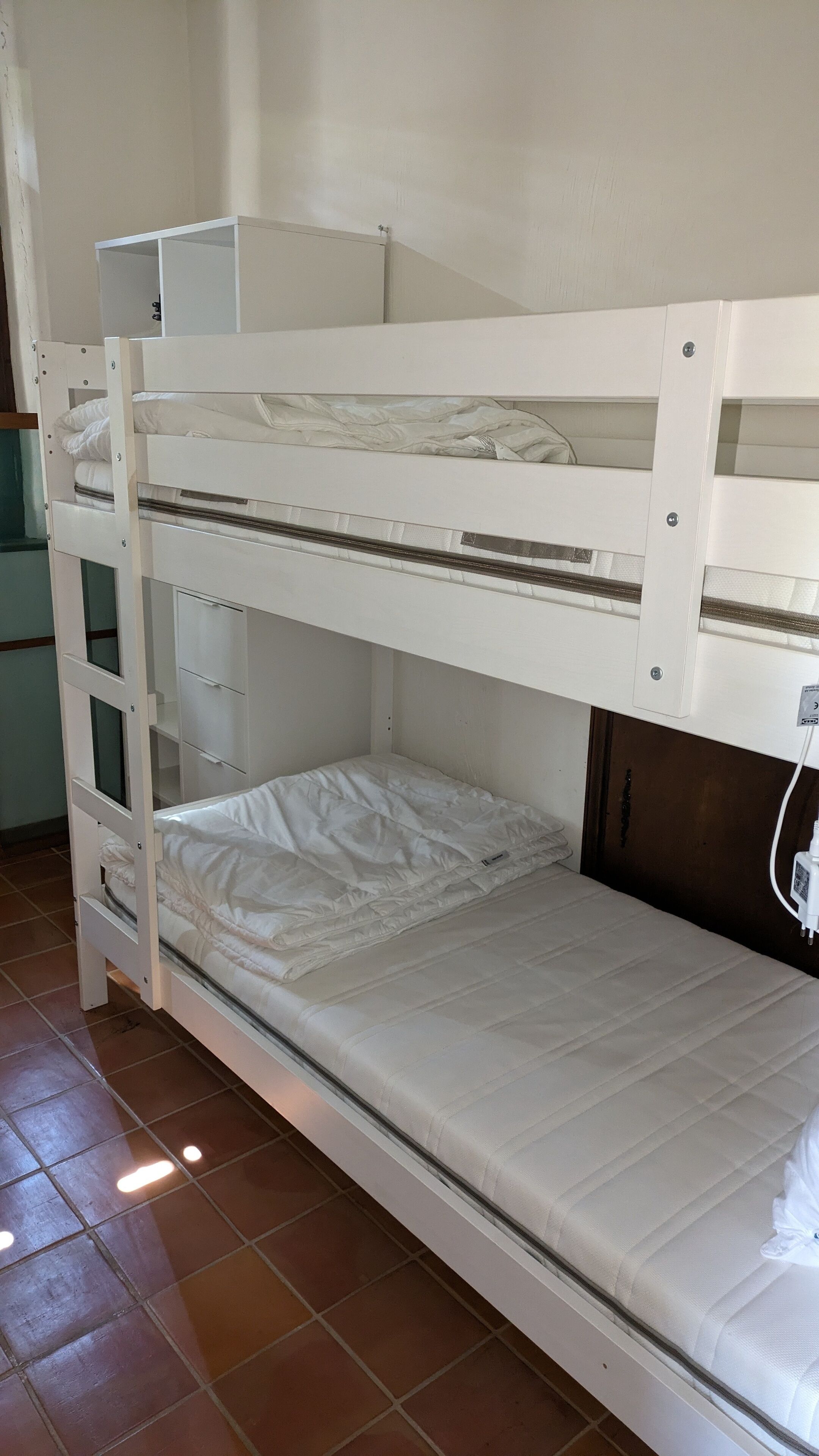 A bunk bed with a lower bunk and a storage cabinet below.