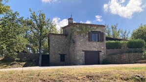 A stone building with a small window and a door, surrounded by trees and a stone wall. - Prachtige villa met privézwembad (Fayence)