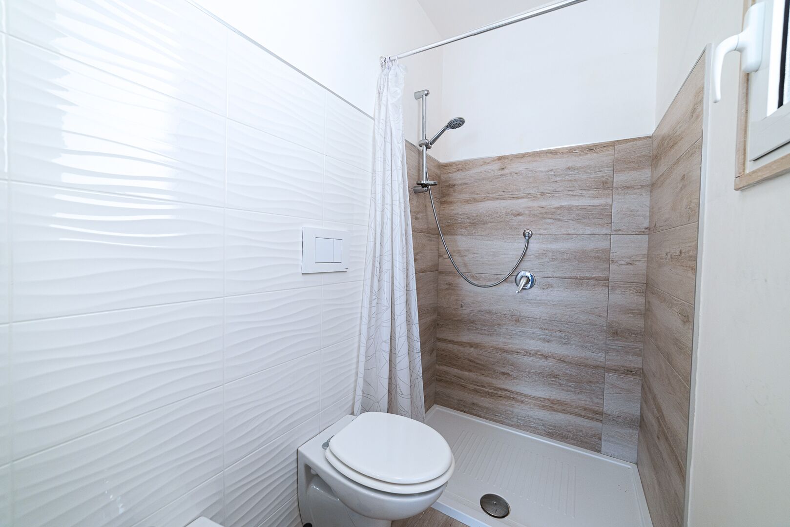 Ein Badezimmer mit Dusche, Toilette und Handtuchhalter.