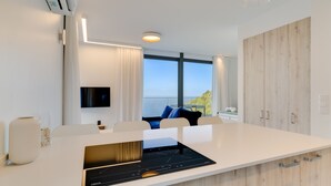 A modern kitchen with a large island, built-in appliances, and a view of the sea. - Mar Yam View by Atlantic Holiday (Santana)