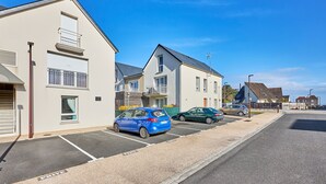 A row of modern, two-story buildings with a parking lot in front. - Les Anémones de Langrune - Avec jardin clos (Langrune-sur-Mer)