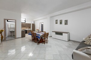 Un apartamento moderno con comedor, kitchenette y sala de estar.