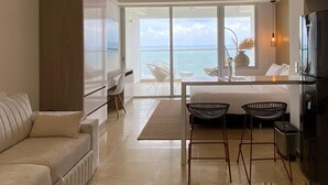 A modern hotel room with a balcony, a bed, a desk, and a sofa. - Wynwood Cartagena Beach (Cartagena)