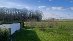 A view of a green field with a white building, trees, and a clear sky. - 2 BRIGHT ROOMS IN A HOMESTAY (Quincy-Voisins)
