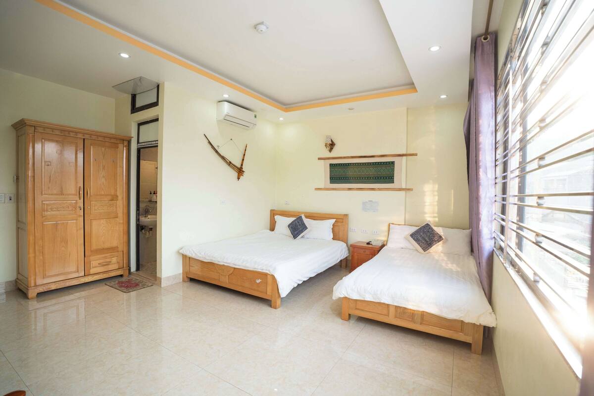Un dormitorio con dos camas de madera, un armario y una ventana con persianas.