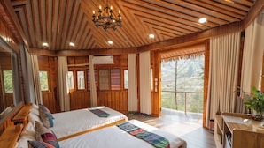 A spacious bedroom with two large beds, wooden ceiling beams, and a balcony with a view of the outdoors. - Sinai Bungalow & Hotel SaPa (Sa Pa)
