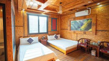 Um quarto estilo cabana de madeira com duas camas, uma mesa, cadeiras, uma janela e um aparelho de ar condicionado.