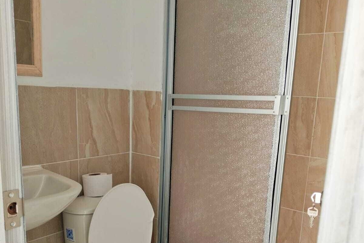 Un baño con inodoro, lavamanos y zona de ducha.