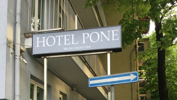 Un panneau indiquant un hôtel, avec l’inscription « HÔTEL PONE » et une flèche directionnelle.