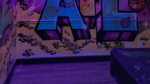 Une pièce décorée de graffitis, avec un ballon de basket et une fenêtre.