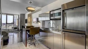 A modern kitchen with stainless steel appliances, a bar area, and a city view. - Strip View Luxury Studio No Resort Fee Palms Place (Las Vegas)