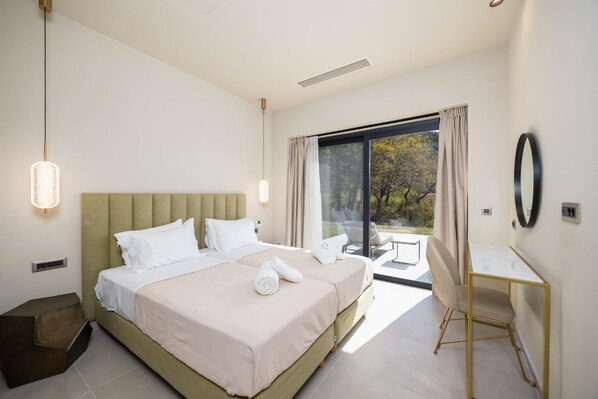 Ein modernes Hotelzimmer mit einem großen Bett, einem Schreibtisch und Blick ins Freie.