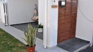 A modern building entrance with a wooden gate, a potted plant, and a sign that reads "LAVANDER."