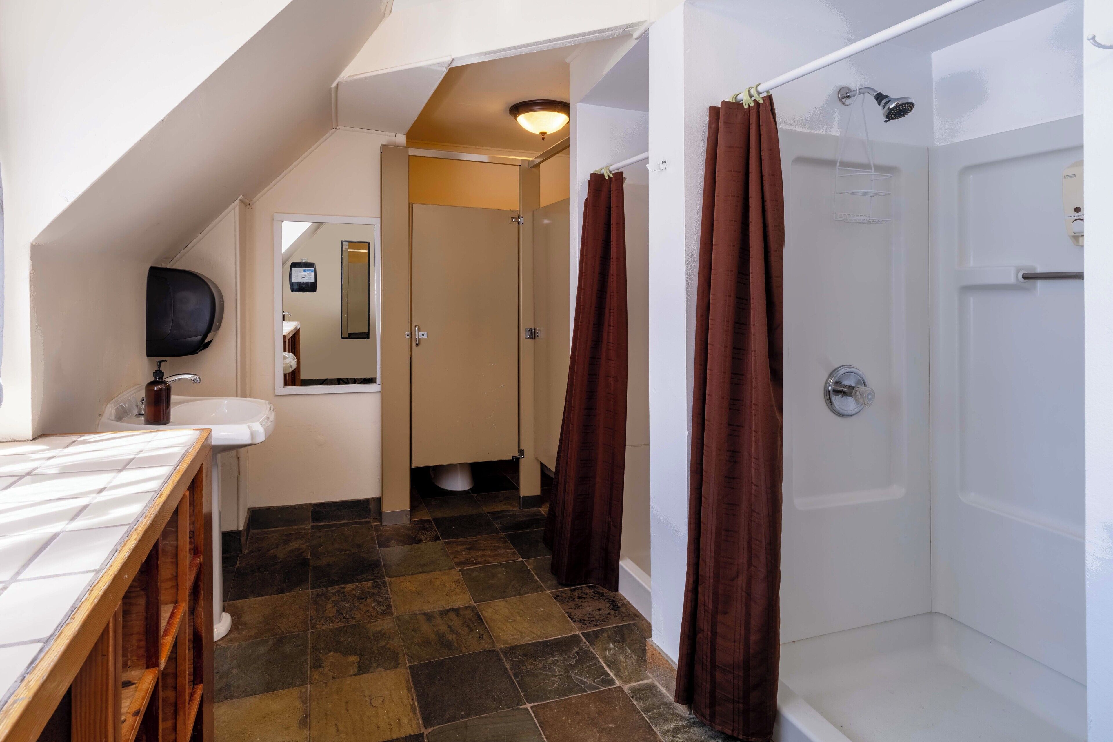 A bathroom with a shower, a sink, and a mirror.
