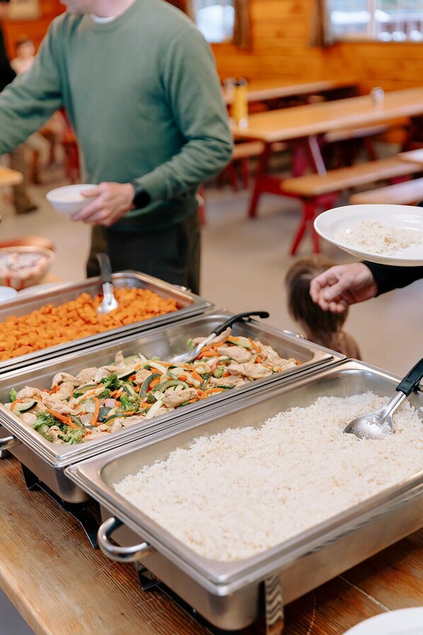 A buffet with various food options including rice, a chicken dish, and a vegetable stir-fry. - Clair Tappaan Lodge (Soda Springs)