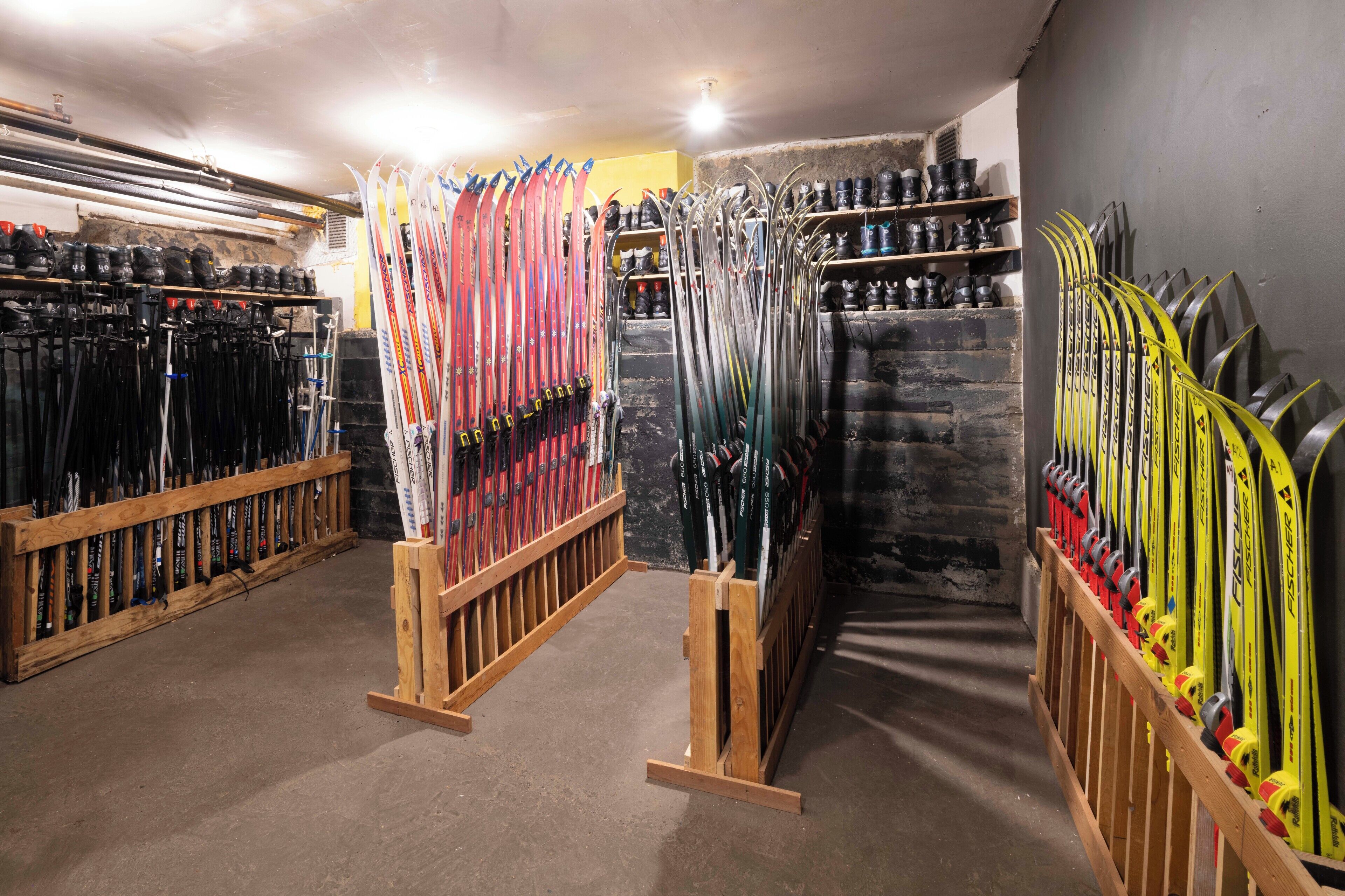 A ski rental facility with multiple ski racks and a stone wall.