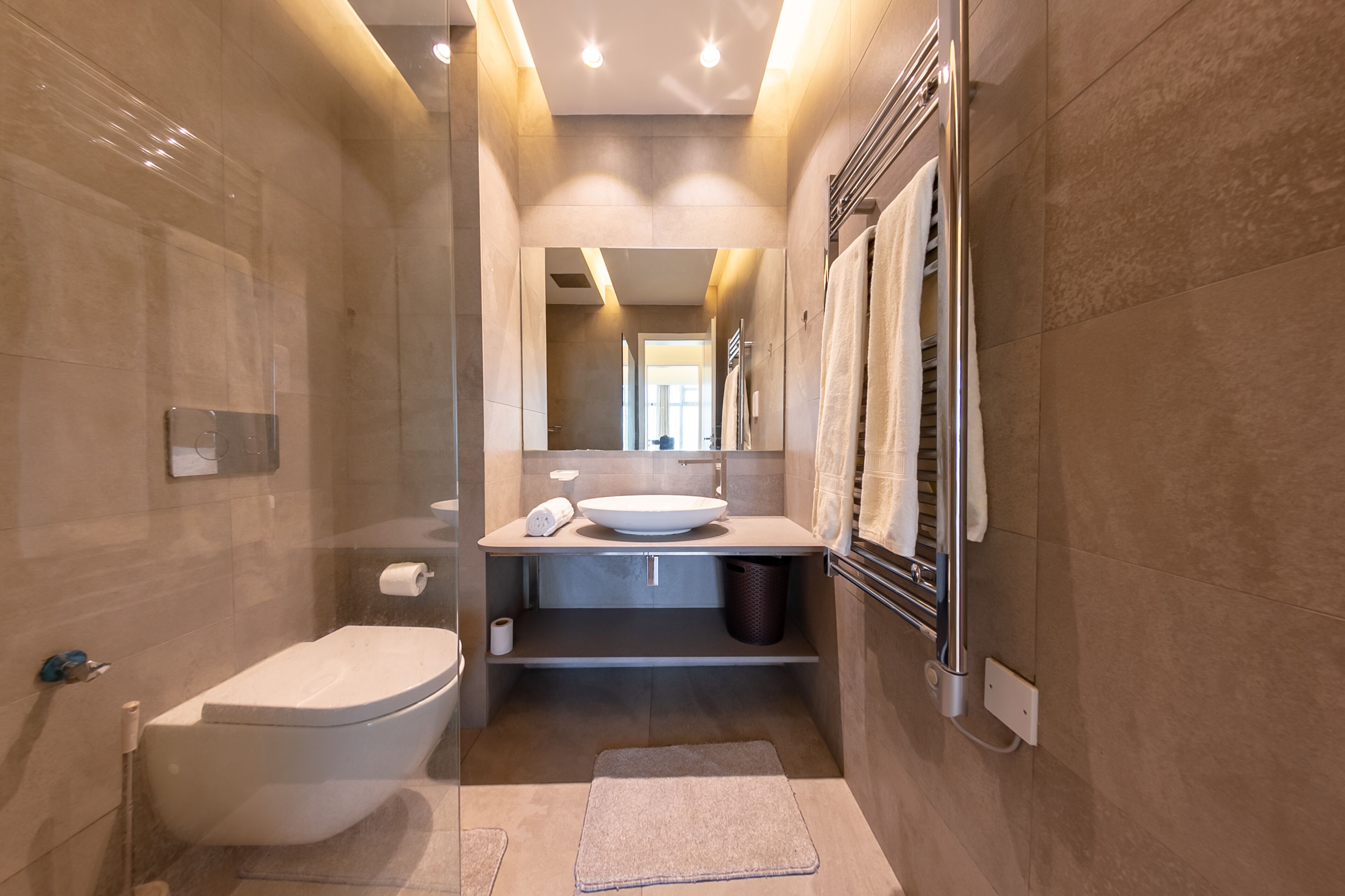 A modern bathroom with a toilet, sink, and shower.