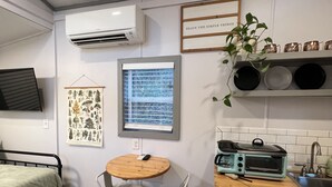 Una cucina compatta con un piccolo angolo ristoro, un forno a incasso e una finestra con persiane.