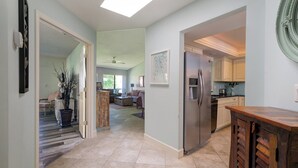 A spacious kitchen with a refrigerator, wooden cabinets, and a countertop.