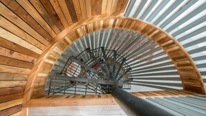 A spiral staircase with wooden railings and a metal handrail.