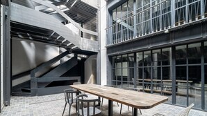 A modern interior with a wooden table and chairs, a staircase, and large windows. - RA Apartments (Istanbul)