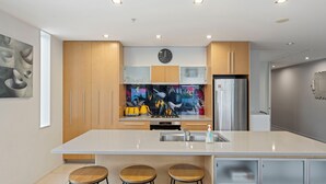 A modern kitchen with a large island, stainless steel appliances, and a colorful backsplash. - Waimahana 5 - Taupo Holiday Apartment (Taupo)