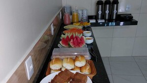 En buffet med forskellige spisemuligheder, blandt andet brød, kager og frugt.