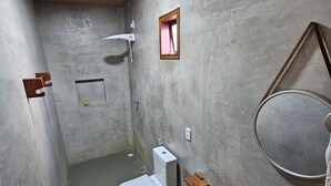 Une petite salle de bain comprenant des toilettes, un lavabo et une douche.