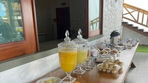 Une table de buffet proposant une variété de plats et de boissons, notamment des fruits, des légumes et un coin café.