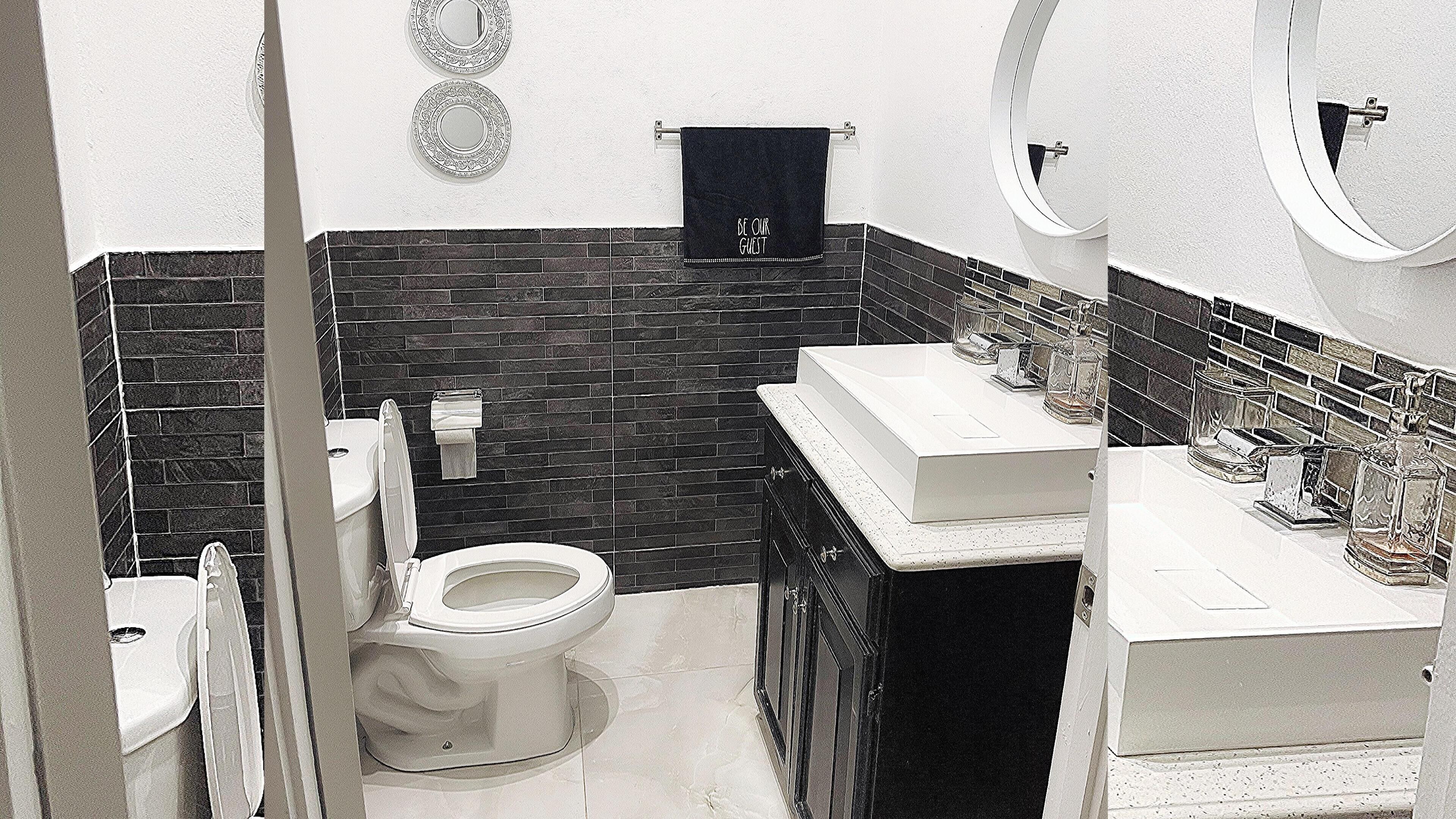Une salle de bain avec des toilettes, un lavabo et un miroir.
