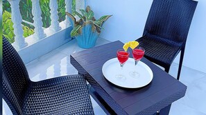 A table with a tray holding two red drinks and a yellow garnish, surrounded by black wicker chairs. - Attalia Villa 5-bed in Runaway Bay Near Ocho Rios (Runaway Bay)