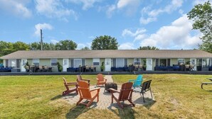 Un motel doté d’un espace extérieur avec des sièges et d’un foyer.