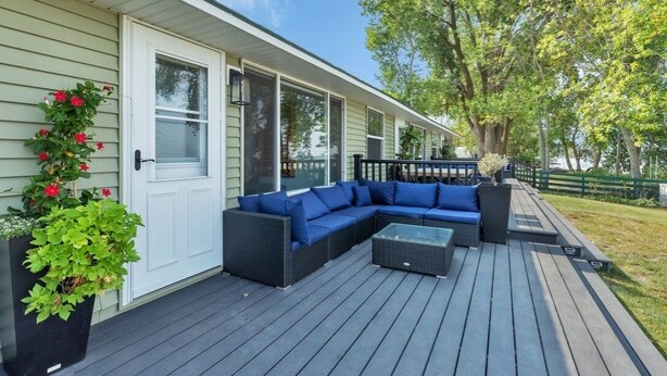 Une terrasse extérieure couverte, aménagée avec un canapé modulable et une table basse.