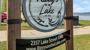 Une enseigne indiquant « Rizzy's on the Lake », avec une vue sur le lac en arrière-plan.