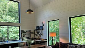 Una cocina amplia con comedor, ventanas grandes y una zona de estar acogedora con sofá y mesa.