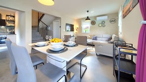 A modern kitchen with a dining area, a staircase, and a living room with a sofa and a coffee table. - Villa Melody with heated pool and sauna (Kvarner - Sveti Ivan Dobrinjski) (Sveti Ivan Dobrinjski)