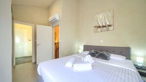 A hotel room with a large bed, a painting on the wall, and an air conditioning unit. - Villa Melody with heated pool and sauna (Kvarner - Sveti Ivan Dobrinjski) (Sveti Ivan Dobrinjski)