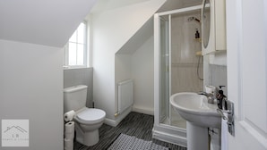 A modern bathroom with a toilet, shower, and sink. - Comfy House - Sleeps 14 - 14 min to City Centre (Manchester)