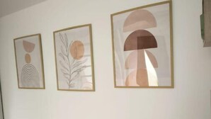 Un mur orné de trois œuvres d’art abstraites encadrées.