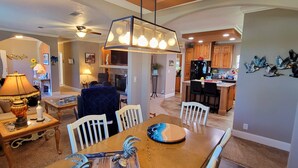 A spacious living room with a dining area, a kitchen, and a fireplace. - The Red Sisters Retreat.  (Edgewater)