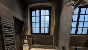 Une salle de bain moderne avec une baignoire sur pieds, des toilettes et un lavabo.