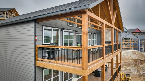 A modern building with a wooden deck and large windows. - Branson Vacation Rental w/ Table Rock Lake Views!  (Branson)