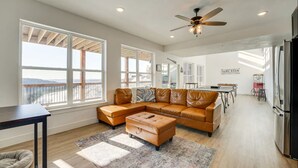 A spacious living room with a large sectional sofa, a coffee table, and a ceiling fan. - Branson Vacation Rental w/ Table Rock Lake Views!  (Branson)