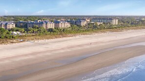 Ein Küstenhotel mit mehreren Gebäuden, einem Sandstrand und Blick auf den Ozean.