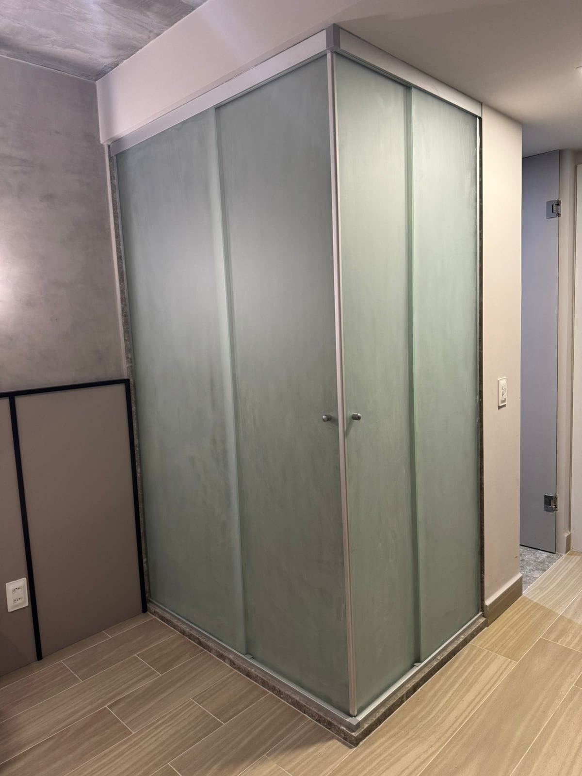 Una habitación con un amplio ventanal corredera, piso de tonos claros y una vista parcial de una puerta que da a otra estancia.