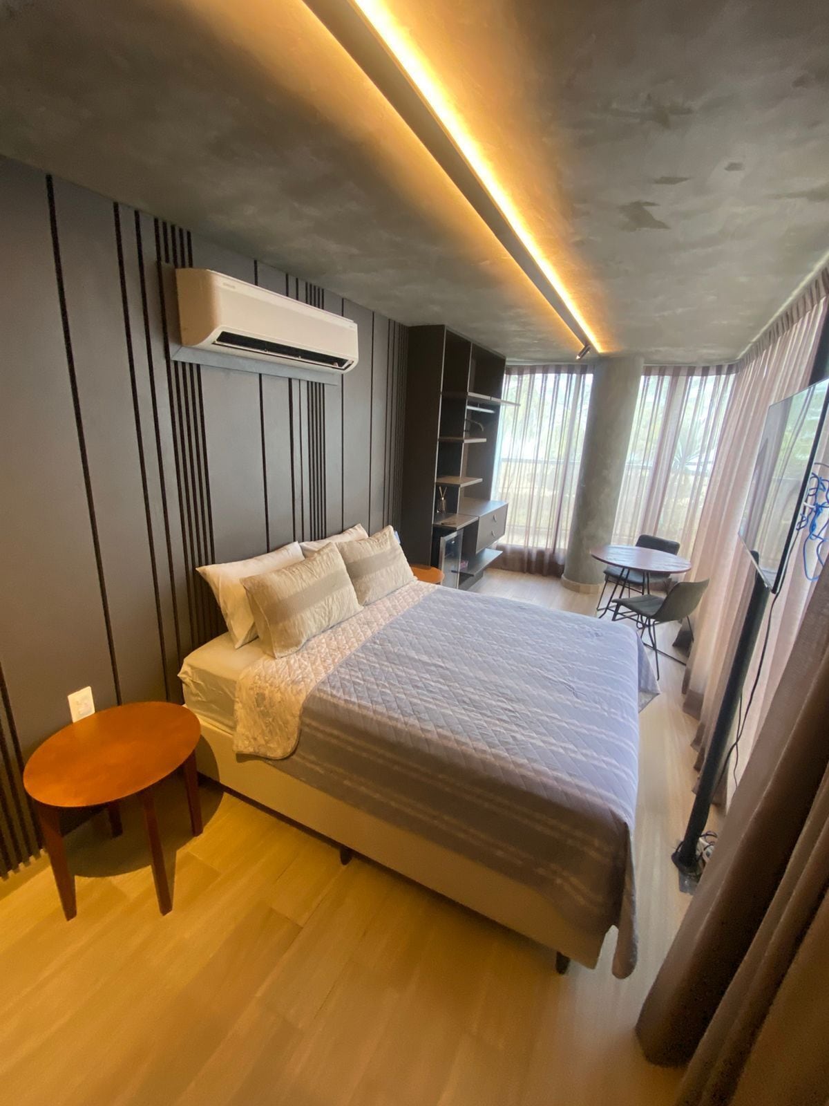 Une chambre à coucher moderne avec un grand lit, une petite table et une chaise.