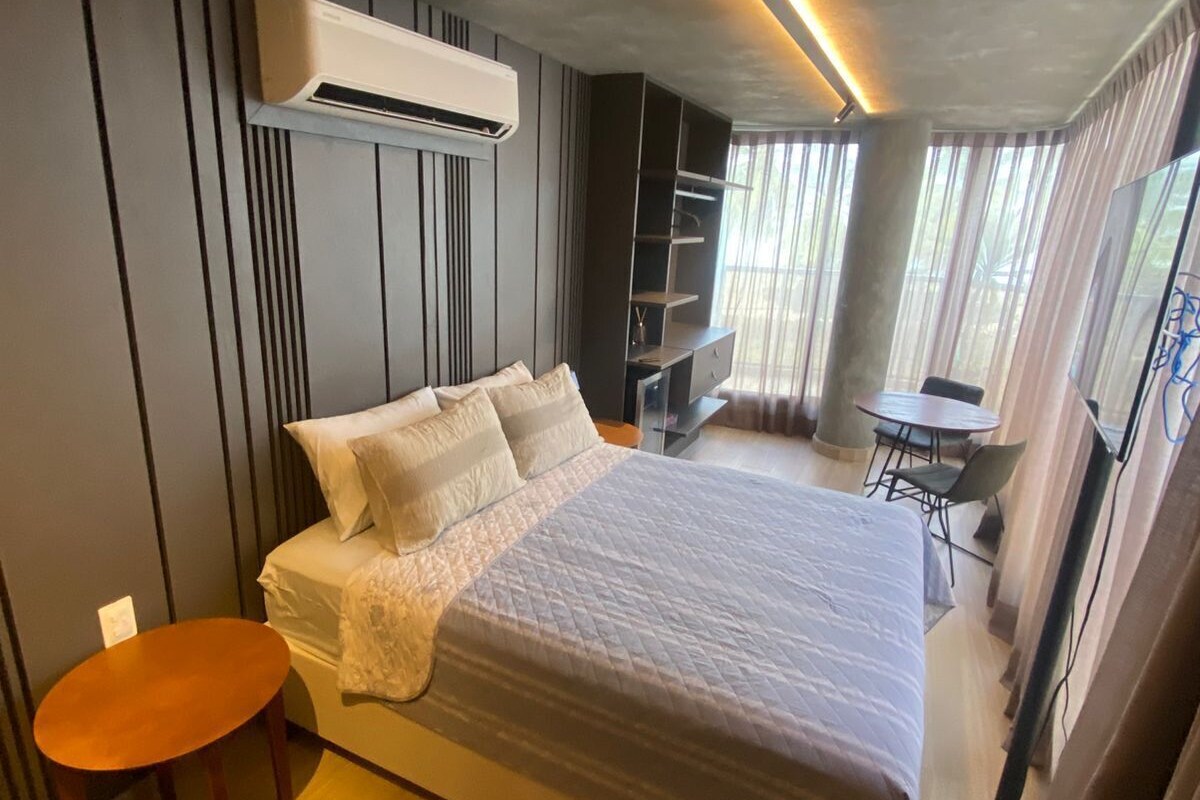 Een moderne slaapkamer met een groot bed, een klein tafeltje en een stoel.